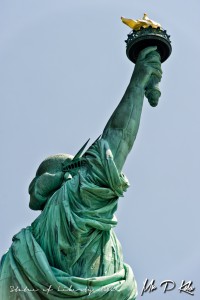 Statue-of-Liberty-upper-body-shot-with-torch-held-aloft-from-behind